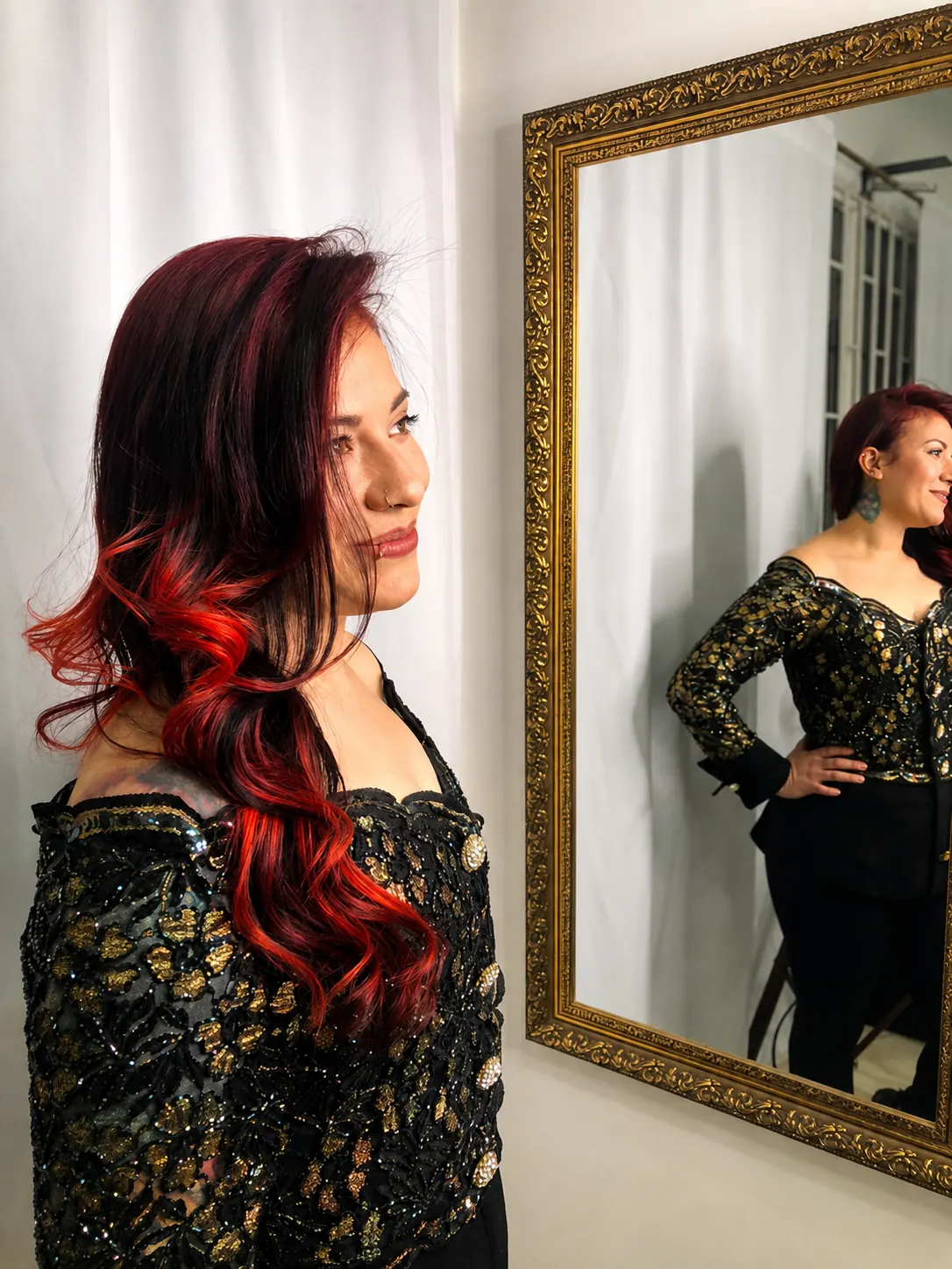 Gina Vargas, tattoo artist, portrait in front of a gilded mirror